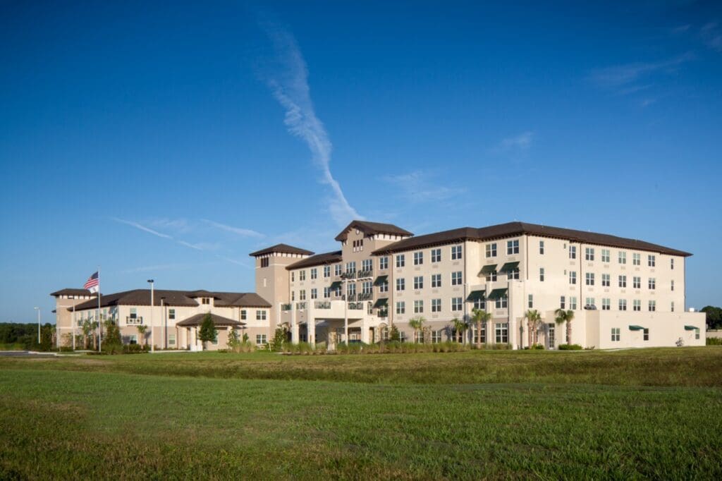 The Summit of Lakewood Ranch building in daylight, surrounded by green grass and palm trees.