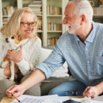 April 25 Events Page Image - The Summit of Lakewood Ranch Elderly man and woman smiling and holding small dog
